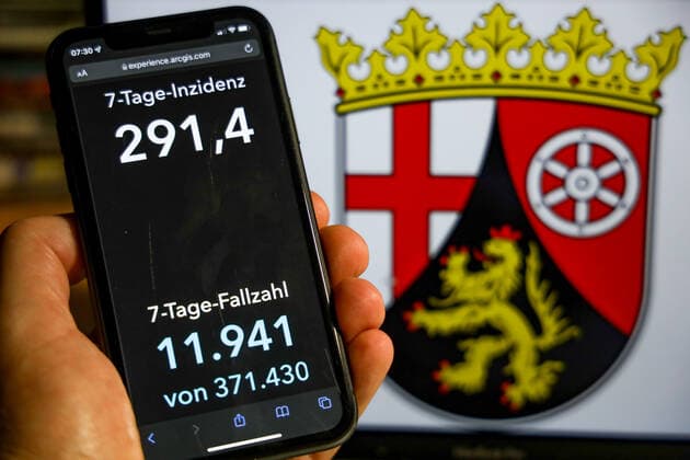 Coronavirus in Deutschland - Covid-19-Dashboard des Robert Koch-Institut DEU, Deutschland, Rheinland-Pfalz 28.11.2021: Die 7-Tage-Inzidenz für das Bundesland (Fälle letzte 7 Tage 100.000 EW) wird auf einem iPhone angezeigt, im Hintergrund das Landeswappen