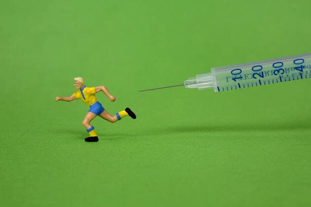 Fussballspielerfigur und Spritze Fussballspielerfigur und Spritze, 28.11.2021, Borkwalde, Brandenburg, Hinter einer Fussballspielerfigur befindet sich eine Spritze.