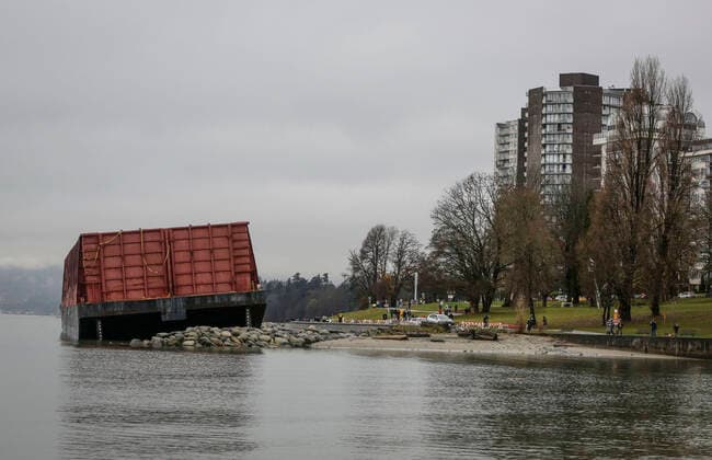 (211129) -- VANCOUVER, Nov. 29, 2021 -- The barge is seen at the shore of Sunset Beach in Vancouver, Canada, Nov. 28, 2021. The barge was washed up on Sunset Beach two weeks ago due to the windstorm. (Photo by Xinhua) CANADA-VANCOUVER-BARGE-BEACH LiangxSen 