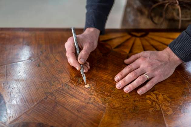 UK, Darlington, Hands of restorer working on marquetry side table UK, Darlington, Hands of restorer working on marquetry side table