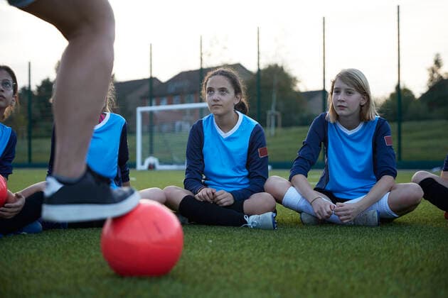 IMAGO Creative: Lokalhelden - Jugendsportbildung UK, Female soccer team (10-11, 12-13) sitting in field during training UK, Female soccer team sitting in field during training