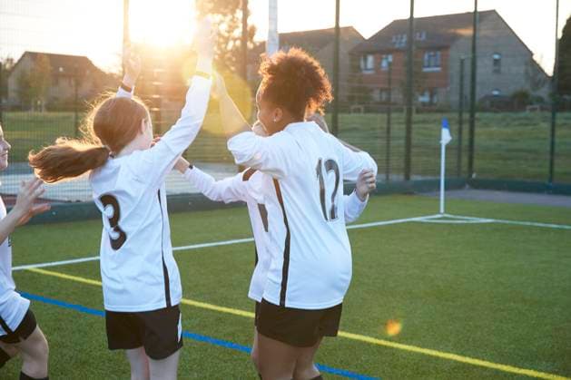 UK, Female soccer players (10-11, 12-13) cheering in field UK, Female soccer players cheering in field