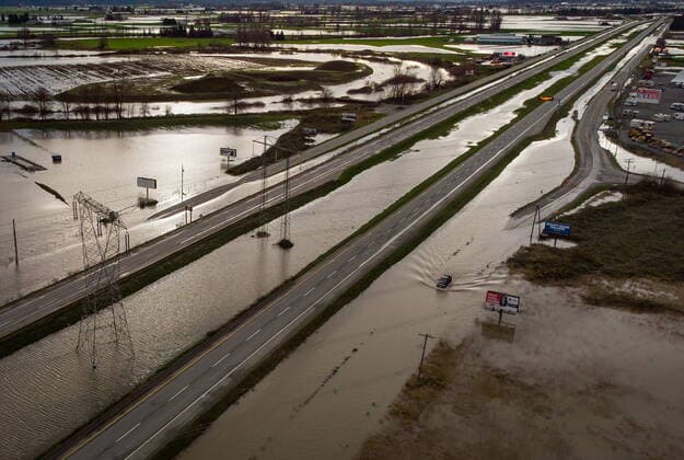December 1, 2021, ABBOTSFORD, BC, CANADA: A motorist drives on a service road along the closed Trans-Canada Highway as floodwaters fill the ditches beside the highway and farmland in Abbotsford, B.C., on Wednesday, December 1, 2021. ABBOTSFORD CANADA  - ZUMAc35_ 20211201_zaf_c35_097 Copyright: xDarrylxDyckx