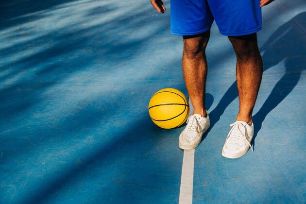 Creative Highlights Symbolbilder Cropped unrecognizable African American sportsman in activewear standing on sports stadium and holding basketball ball, Model released AlbaCaro_Basketball_24.jpg Copyright: xAlbaxCarox MR