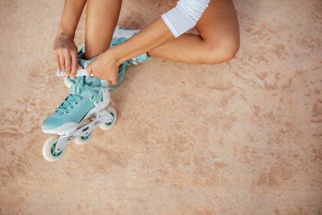 IMAGO Creative: Sport in der Stadt Crop of anonymous sportive female tying laces on roller skates while sitting on paved before training in city DaniNavarro_RollerSkaterYoungWoman_26.jpg Copyright: xDanixNavarrox Model Released