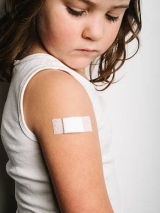 Side view of schoolgirl after vaccination standing with band aid on arm, Model released HodeiUnzueta_VaccinatedKids_24.jpg Copyright: xHodeixUnzuetax MR