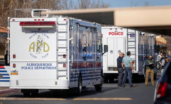 December 2, 2021, Albuquerque, New Mexico, USA: Albuquerque..A group of officers and investigators talk between the two mobile crime labs in the parking lot of the Villa Hermosa apartment complex, as they investigate an Officer Involved Shooting on December 02, 2021. for the Albuquerque Journal.Albuquerque, New Mexico Albuquerque USA - ZUMAab1_ 20211202_zaf_ab1_012 Copyright: xMikexSandovalx