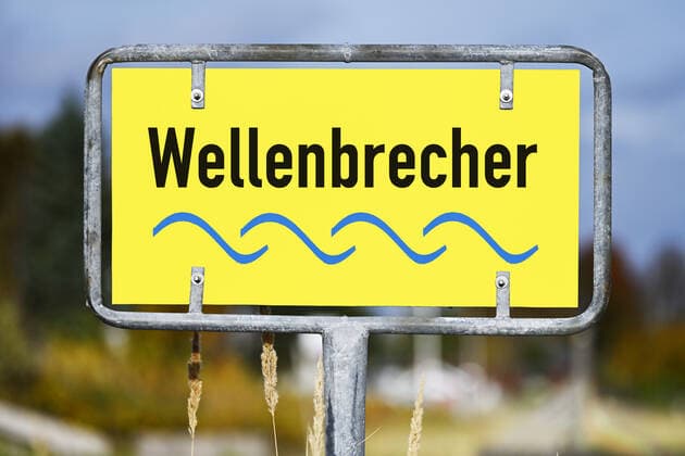 FOTOMONTAGE, Schild mit Aufschrift Wellenbrecher, Wort des Jahres 2021 *** PHOTOMONTAGE, sign with inscription breakwater, word of the year 2021 ** NUR FUER REDAKTIONELLE ZWECKE ** EDITORIAL USE ONLY **