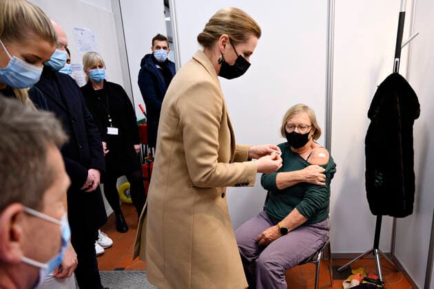 Statsminister Mette Frederiksen (S) saetter plaster paa og direktoer i Sundhedsstyrelsen Soeren Brostroem vaccinerer, da de besoeger covid-19-vaccinationsstedet i det gamle billetkontor paa Koebenhavns Hovedbanegaard, fredag den 3. december 2021. Statsministeren og Soeren Brostroem faar en rundvisning paa det nyaabnede vaccinationssted bl.a. i anledning, af at myndighederne har opfordret danskerne til at faa det tredje stik imod coronavirus.. , Copenhagen Denmark Copyright: PhilipxDavali PhilipxDavalix cop105 spdk20211203-161031-L