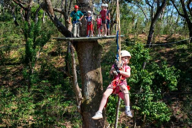 Young girl in a Canopy Adventure CafÃ Las Flores Nicaragua Central America. Zip line across the treetops using the most advanced high angle equipment and technology. CafÃ Las Flores Canopy Adventureâ ¢ is an energizing 1.5 hours of fun, which includes stops on 11 different wood and glass fiber platforms, 7 separate zip lines, and games like the boomerang, double cross, the Tarzan swing and a thrilling vertical rappel descent. Nicaragua Copyright: xSergixReboredox xVWPicsx SRE-079-CY1395