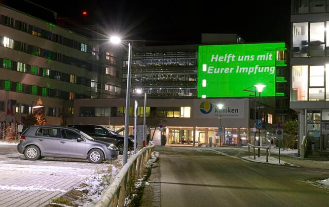 04.12.2021, Seit Freitagabend 03.12.2021 sorgt eine spektakuläre Fassaden-Projektion am Kaufbeurer Klinikum mit dem Hilferuf SOS, und Wir kämpfen für Euch und Helft uns mit Eurer Impfung für Aufmerksamkeit und verweisen so auf den mittlerweile kritischen Zustand auf den Intensivstationen im Zusammenhang mit Covid-19. Seit Wochen sind alle 14 Intensiv-Betten durchgehend belegt, alle Corona-Patienen derzeit seien ungeimpft und werden beatmet. Deswegen ruft die Klinik-Leitung mit dieser Aktion die Bevölkerung dringend zur Covid-Impfung auf. 04.12.2021, Kaufbeuren Klinikum SOS-Hilferuf 04.12.2021, Kaufbeuren Klinikum SOS-Hilferuf