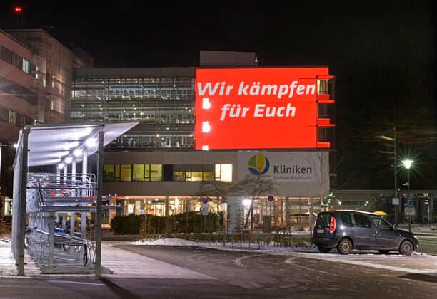 04.12.2021, Seit Freitagabend 03.12.2021 sorgt eine spektakuläre Fassaden-Projektion am Kaufbeurer Klinikum mit dem Hilferuf SOS, und Wir kämpfen für Euch und Helft uns mit Eurer Impfung für Aufmerksamkeit und verweisen so auf den mittlerweile kritischen Zustand auf den Intensivstationen im Zusammenhang mit Covid-19. Seit Wochen sind alle 14 Intensiv-Betten durchgehend belegt, alle Corona-Patienen derzeit seien ungeimpft und werden beatmet. Deswegen ruft die Klinik-Leitung mit dieser Aktion die Bevölkerung dringend zur Covid-Impfung auf. 04.12.2021, Kaufbeuren Klinikum SOS-Hilferuf 04.12.2021, Kaufbeuren Klinikum SOS-Hilferuf