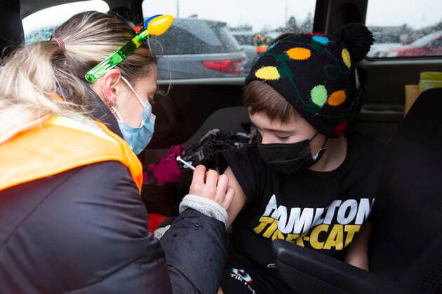 December 4, 2021, Kingston, Ontario, Canada: Medical student Celine Lecce gives Anthony Marcucci, 10, his vaccine during a drive-thru COVID-19 vaccine clinic at St Lawrence College in Kingston, Ont., Saturday, Dec. 4, 2021. Kingston Canada - ZUMAc35_ 20211204_zaf_c35_008 Copyright: xLarsxHagbergx