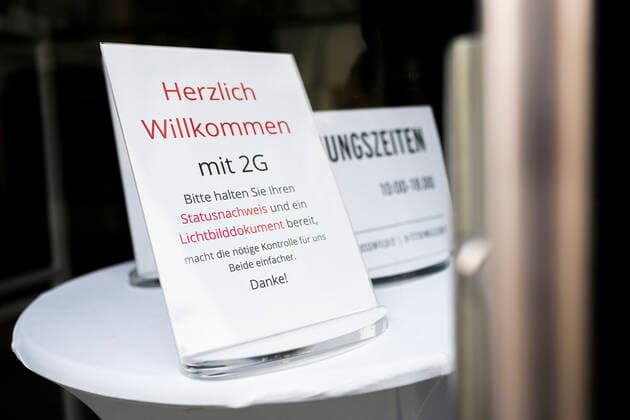 HINWEIS ZU CORONA ZUGANGSBESCHRÄNKUNGEN 05 12 2021 - Erfurt: Ein Schild weißt auf die 2G-Regel am Eingang eines Geschäfts in der Erfurter Innenstadt am 5. Dezember 2021 hin. _________________