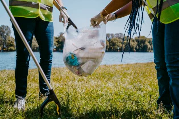 IMAGO Creative: Neue Aussichten Low section of female volunteers cleaning plastics at lakeshore Germany, Berlin, model released Copyright: xMaskotx , MA90309