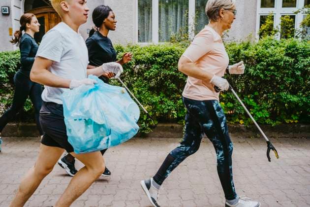 IMAGO Creative: Menschen in Berlin - Generationen Male and female environmentalists plogging with plastic bag on footpath Germany, Berlin, model released Copyright: xMaskotx , MA90394