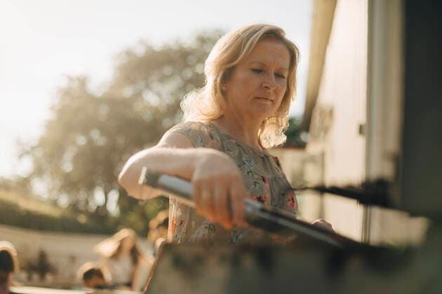 IMAGO Creative: Landleben - Essen IMAGO Creative: Landleben - Alfresco, Draußen Mature woman preparing food on barbecue grill during dinner party Sweden, Stockholm, model released, property released Copyright: xMaskotx , MA90501