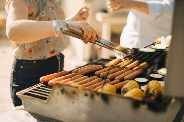 Midsection of woman preparing food on barbecue grill during garden party Sweden, Stockholm, model released, property released Copyright: xMaskotx , MA90502