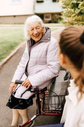 Happy elderly woman talking with female caregiver in front yard Sweden, Gothenburg, model released, property released Copyright: xMaskotx , MA90704