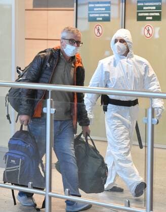 Russia South Africa Coronavirus 6714238 07.12.2021 An airport employee in protective gear escorts a passenger arrived from South Africa for further transfer to an observation facility in Sergiev Posad, amid the coronavirus disease outbreak with the emergence of the Omicron variant, at the Domodedovo International Airport named after Mikhail Lomonosov outside Moscow, Russia. Russian health authorities on December 6, said they have confirmed the first two cases of the omicron variant of coronavirus in travelers who returned from South Africa. Mikhail Voskresenskiy Sputnik Moscow region Russia  Copyright: xMikhailxVoskresenskiyx