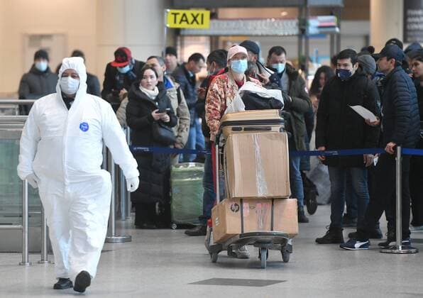 Russia South Africa Coronavirus 6714246 07.12.2021 An airport employee in protective gear escorts a passenger arrived from South Africa for further transfer to an observation facility in Sergiev Posad, amid the coronavirus disease outbreak with the emergence of the Omicron variant, at the Domodedovo International Airport named after Mikhail Lomonosov outside Moscow, Russia. Russian health authorities on December 6, said they have confirmed the first two cases of the omicron variant of coronavirus in travelers who returned from South Africa. Mikhail Voskresenskiy Sputnik Moscow region Russia  Copyright: xMikhailxVoskresenskiyx