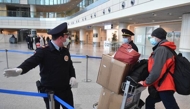 Russia South Africa Coronavirus 6714249 07.12.2021 Police officers direct a passenger arrived from South Africa for further transfer to an observation facility in Sergiev Posad, amid the coronavirus disease outbreak with the emergence of the Omicron variant, at the Domodedovo International Airport named after Mikhail Lomonosov outside Moscow, Russia. Russian health authorities on December 6, said they have confirmed the first two cases of the omicron variant of coronavirus in travelers who returned from South Africa. Mikhail Voskresenskiy Sputnik Moscow region Russia  Copyright: xMikhailxVoskresenskiyx