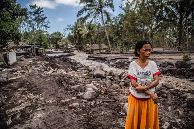 Bilder des Jahres 2021, News 12 Dezember News Themen der Woche KW49 December 9, 2021, Kamar Kajang, East Java, Indonesia: A woman looks at her house that was buried by volcanic ash in Kamar Kajang, Lumajang. At least 14 people are dead and dozens are injured after Mount Semeru, a volcano in Indonesia s East Java province, erupted on Saturday, throwing towers of ash and hot clouds that covered nearby villages. Kamar Kajang Indonesia - ZUMAs197 20211209_zaa_s197_005 Copyright: xAdityaxSaputrax