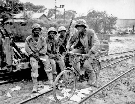 Black Marines, attached to the 3rd Ammunition Company, take time out from supplying ammunition to the front line on Saipan. Riding a captured bicycle is Pfc. Horace Boykin while (left to right) Cpl. Willis T. Anthony, Pfc. Emmitt Shackelford and Pfc. Eugene Purdy watch, June 1944. . . 1062_05_L_-10454-