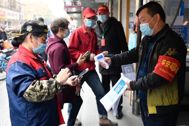(211210) -- HANGZHOU, Dec. 10, 2021 -- A volunteer checks health codes and body temperatures at the entrance of a market in Hangzhou, east China s Zhejiang Province, Dec. 10, 2021. Eight urban districts of Hangzhou have asked public places, including libraries, museums, theaters and internet cafes, to limit visitors to no more than half of their total capacity. ) CHINA-ZHEJIANG-COVID-19-NUCLEIC ACID TEST (CN) HuangxZongzhi 