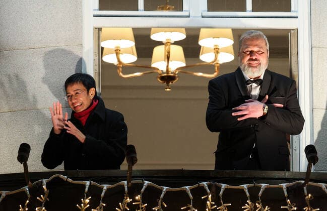 OSLO, NORWAY â€“ DECEMBER 10, 2021: Nobel Peace Prize winners, Filipino-American journalist, co-founder and CEO of Rappler Maria Ressa (L) and Russian journalist, Novaya Gazeta newspaper editor-in-chief Dmitry Muratov greet the participants in a torchlight parade in honour of the 2021 Nobel Peace Prize winners from a balcony of the Grand Hotel. The Norwegian Nobel Committee has decided to award the Nobel Peace Prize for 2021 to Filipino-American journalist, co-founder and CEO of Rappler Maria Ressa and Russian journalist, Novaya Gazeta editor-in-chief Dmitry Muratov in recognition of their efforts to safeguard freedom of expression, which is a precondition for democracy and lasting peace . Sergei Bobylev TASS  TS11B696