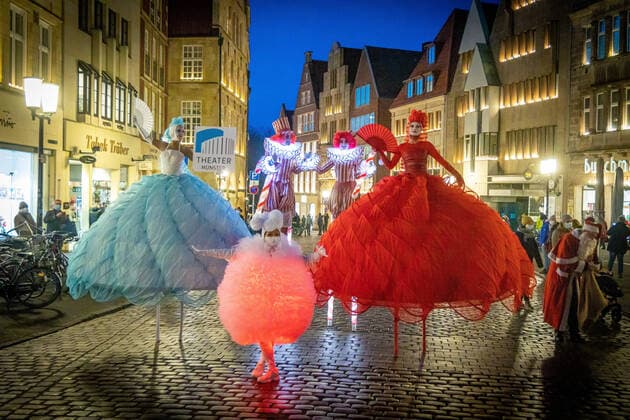 Bilder des Jahres 2021, Entertainment 12 Dezember Entertainment Themen der Woche KW49 Werbeaktion des Theater Münster in der Innenstadt von Münster DEU, Deutschland, Nordrhein-Westfalen, Münster, 10.12.2021: Stelzenläufer in buntem Fantasiekostüm. Mitglieder der Berliner Dulce Compania laufen Werbung für das Theaterprogramm der Spielzeit 2021 2022 des Theater Münster *** Advertising campaign of the Theater Münster in the city centre of Münster DEU, Germany, North Rhine Westphalia, Münster, 10 12 2021 Stilt walkers in colourful fantasy costumes Members of the Berlin Dulce Compania run advertising for the theatre programme of the 2021 2022 season of the Theater Münster
