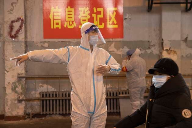 (211212) -- HARBIN, Dec. 12, 2021 -- Guan Chao works at a nucleic acid testing site in Harbin, capital of northeast China s Heilongjiang Province, Dec. 11, 2021. Clad in protective gear, Guan Chao started his volunteer work with his mother Wang Tao as usual. Guan, 27, is a dance teacher. Due to the latest resurgence of COVID-19 cases in Harbin, his offline teaching routine has been disrupted. Guan joined the fight against the epidemic. He became a volunteer for the citywide nucleic acid testing, medical supplies delivery and regular disinfection on public spaces. Seeing medical staff, community workers and volunteers work day and night, Guan s mother Wang Tao also joined the efforts. Wearing a red volunteer waistcoat and a face mas