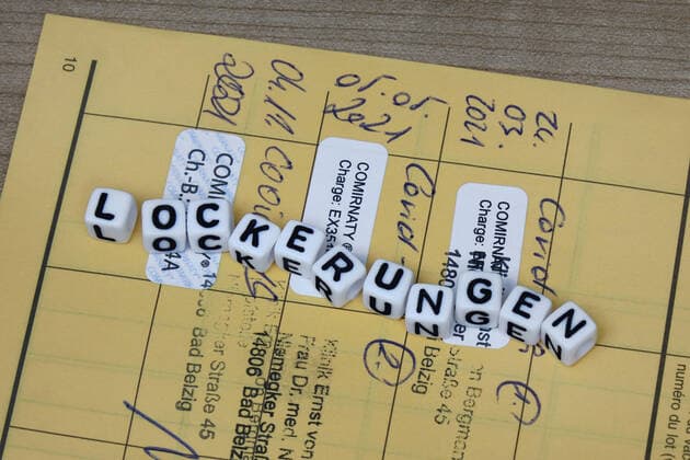 Impfausweis mit Schriftzug Lockerungen Impfausweis mit Schriftzug Lockerungen, 11.12.2021, Borkwalde, Brandenburg, Auf einem Impfausweis liegen Buchstabenwürfel mit dem Schriftzug Lockerungen.