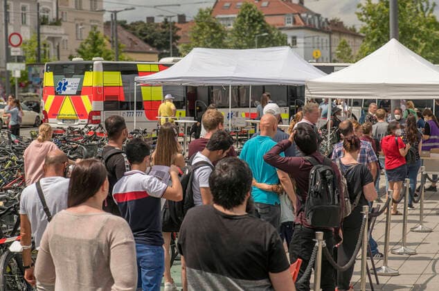 Schlange am Impfbus in Muenchen-Pasing, Impfkampagne der Stadt Muenchen, Juli 2021 DEU, Deutschland, Muenchen, 31. Juli 2021, Impfbus der Aicher Ambulanz am Pasinger Bahnhofsplatz, viele Menschen haben sich angestellt, um sich ohne Voranmeldung impfen zu lassen, Andrang, Schlange, Corona-Schutzimpfung, warten, Impfstation, Impfzentrum, Impfaktion, geimpft, Impfung, spontan, Bus, Impfkampagne der Landeshauptstadt Muenchen, an verschiedenen Stellen der Stadt stehen Impfbusse, Impfung ohne Anmeldung, es werden alle Impfstoffe verimpft, Impfwillige koennen frei waehlen, einzelne Gesichter unkenntlich gemacht, Samstag, Samstagmittag, Corona, Schutz, Corona-Impfung, Impfstoff, Impfungen, Gesundheit, Coronakrise, Corona-Krise, Krise, Corona, Coron