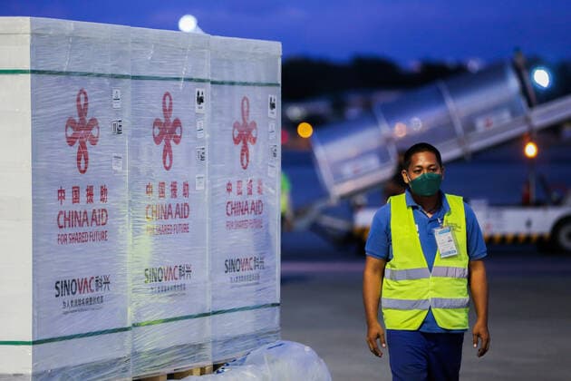 (211214) -- PASAY CITY, Dec. 14, 2021 -- A staff member walks past cargos containing Sinovac vaccines donated by the Chinese government in Pasay City, the Philippines, Dec. 14, 2021. The Philippines received on Tuesday an additional batch of Sinovac vaccines donated by the Chinese government to help the Southeast Asian country recover quickly from the COVID-19 pandemic. ) PHILIPPINES-PASAY CITY-CHINA-DONATED SINOVAC COVID-19 VACCINES ROUELLExUMALI 
