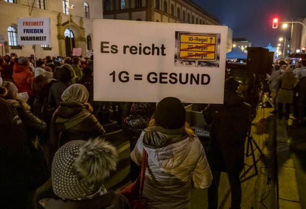 Querdenker-Demo, Ludwigstraße, München 15. Dezember 2021 DEU, Deutschland, München, 15.12.2021, grosse Kundgebung von Corona-Rebellen gegen Coronamassnahmen und Impfpflicht, Dezember 2021, Querdenker Demo, ca. 3500 DemonstrantInnen, 1G, Plakat, Ludwigstrasse, Ecke Schellingstrasse, abends, Bayern, Dezember, Querformat