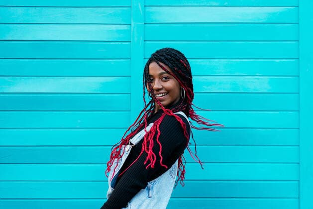 Creative Highlights Symbolbilder Side view of young content black woman with Afro braids looking at camera on blue background, Model released AidaMartinez_AnaAndAicha_7.jpg Copyright: xAidaxMartinezx MR