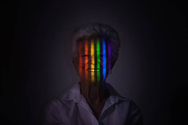 Creative Highlights Symbolbilder Optimistic mature female with projection of spectrum with colorful lights on face looking at camera on black background in dark studio, Model released SergioVictorVega_ConceptosIV_29.jpg Copyright: xSergioxVictorxVegax MR