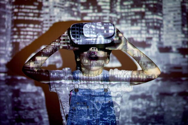 Creative Highlights Symbolbilder Amazed boy in modern VR headset exploring virtual reality while standing near wall with bright projection of megapolis in room, Model released SergioVictorVega_ConceptosIV_5.jpg Copyright: xSergioxVictorxVegax MR