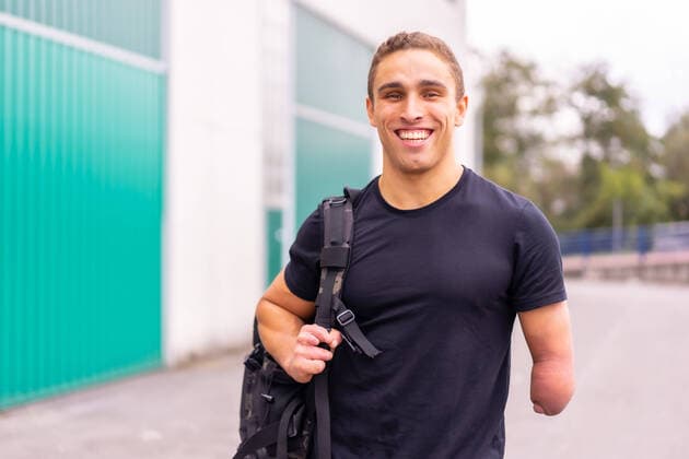 Creative Highlights Symbolbilder Cheerful man with amputated arm smiling and looking at camera while standing on blurred background of street, Model released, Property released UnaiHuici_XabierOsaCrossfit_7.jpg Copyright: xUnaixHuicix MR