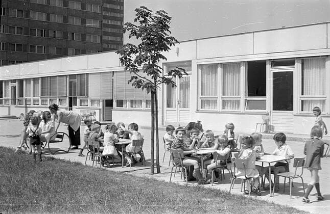 Kinder im Kindergarten DDR 1973 Historisches Bild und Foto: Kindergarten (heute: Fröbel Kindergarten Schatzinsel auf der Fischerinsel 7 8). Spielende Kinder auf einem Klettergerüst vor dem Kindergarten im Sommer, Frühling. Spielende Kinder mit Erzieher in einem Kindergarten in der Deutschen Demokratischen Republik DDR Historical Image and Photography: Kindergarten in Eastberlin. Children in a kindergarten, playschool, nursery school in East Germany 1973 East Berlin