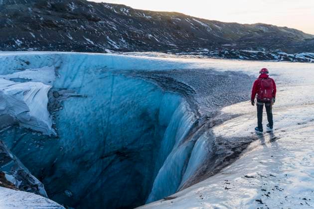 guide exploring sink hole on glacier in Iceland Vik, Iceland CR_THHE211213-885502-01 ,model released, Symbolfoto
