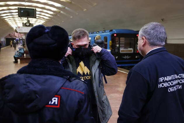 NOVOSIBIRSK, RUSSIA - DECEMBER 17, 2021: Andrei Benimetsky (R), deputy head of the passenger transportation department of the Novosibirsk Region Transport and Road Infrastructure Ministry, and a police officer check face mask compliance at Ploshchad Lenina Station of the Novosibirsk Underground. Russia s Novosibirsk Region has been placed on a high alert amid a rise in COVID-19 cases, the face mask mandate applying to all public venues. Kirill Kukhmar TASS  TS11C19B