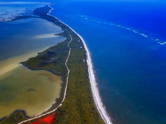 Aerial view of Punta Allen Sian Ka an Reserve, Yucatan Peninsula, Mexico. Red lagoon near Boca Paila Bridge. In the language of the Mayan peoples who once inhabited this region, Sian Ka an means Origin of the Sky. Located on the east coast of the Yucatan peninsula, this biosphere reserve contains tropical forests, mangroves and marshes, as well as a large marine section intersected by a barrier reef. It provides a habitat for a remarkably rich flora and a fauna comprising more than 300 species of birds, as well as a large number of the region s characteristic terrestrial vertebrates, which cohabit in the diverse environment formed by its complex hydrological system. Along its roughly 120 kilometres of coastline, the property covers over Copyright: xSergixReboredox SRE-047-ER2428