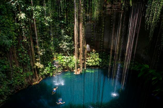 Swimming at Cenote Ik Kil in Yucatan, Mexico, a natural pit, or sinkhole near Chichen Itza. Yucatan Peninsula, Quintana Roo, Mexico. Ik Kil was sacred to the Mayans who used this cenote for both relaxation and ritual services centuries ago. Yucatan Mexico Copyright: xSergixReboredox SRE-051-ER1953