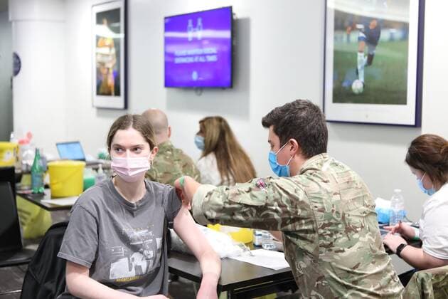 December 18, 2021, London, United Kingdom: A NHS staff from the vaccination team administers a Covid-19 booster jab to a woman at a vaccination centre..The Chelsea Stamford Stadium was used as an NHS vaccination centre providing a marathon of jabs ˜Jabathon™. Bookings began from 10am as members of the military and NHS provided the vaccination. London United Kingdom - ZUMAs197 20211218_zaa_s197_123 Copyright: xBelindaxJiaox