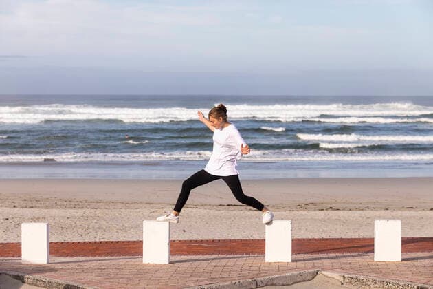 IMAGO Creative: Kulturelle Folgen der Pandemie: Gesundheitsbewußtsein und Alleinsein A teenage girl balancing on posts on a sandy beach. Grotto Beach,South Africa,A teenage girl balancing on posts on a sandy beach.  A teenage girl balancing on posts on a sandy beach.