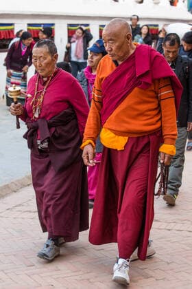 IMAGO Creative: Kollidierende Kulturen A Buddhist monk and nun with mala rosary beads and prayer wheel circumambulate around the Boudhanath Stupa, Kathmandu, Nepal. Kathmandu Boudhanath Bagmati Province Nepal Copyright: xJonxG.xFullerx 4429-JGF-people-worshipping-NP