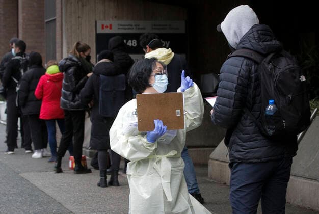 Coronavirus, Eindrücke aus Kanada (211224) -- VANCOUVER, Dec. 24, 2021 -- A health worker talks to a resident at a temporary COVID-19 testing site in Vancouver, Canada, Dec. 23, 2021. Canada set a new daily record of 20,699 COVID-19 cases on Thursday, bringing the cumulative total number to 1,945,754 cases with 30,131 deaths, according to CTV. (Photo by Xinhua) CANADA-COVID-19-CASES-RECORD HIGH LiangxSen