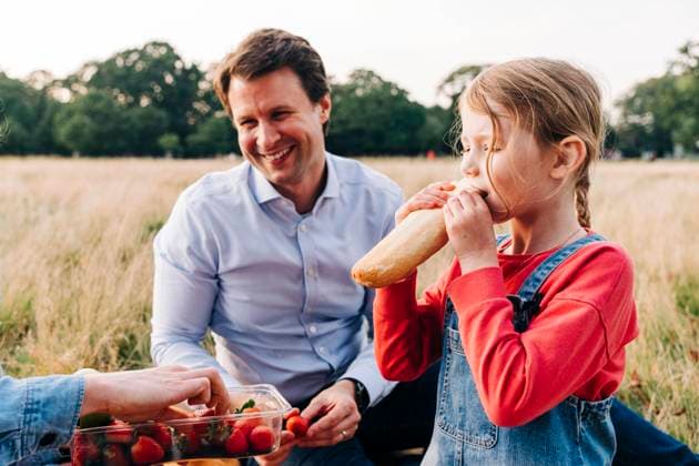Girl eating loaf of bread at picnic with family in park model released, ASGF01675